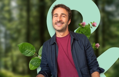 Lächelnder Mann vor Blumen-Hintergrund - Motiv für das Tagesgeld der UmweltBank